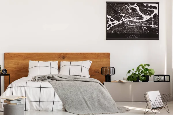 Пространство для копирования на белой стене с черной картой в современной спальне с двуспальной кроватью с деревянным изголовьем — стоковое фото