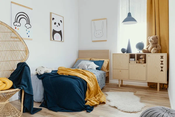Stylowa drewniana kome w jasnym wnętrzu sypialni z plakatem na ścianie — Zdjęcie stockowe