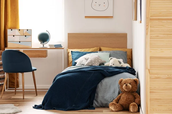 Brown cute teddy bear on wooden floor of stylish bedroom interior for kids — Stock Photo, Image