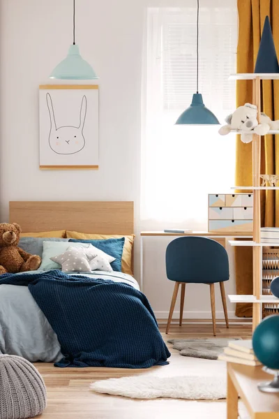 Teddy bear on single wooden bed in blue and orange bedroom interior — Stock Photo, Image