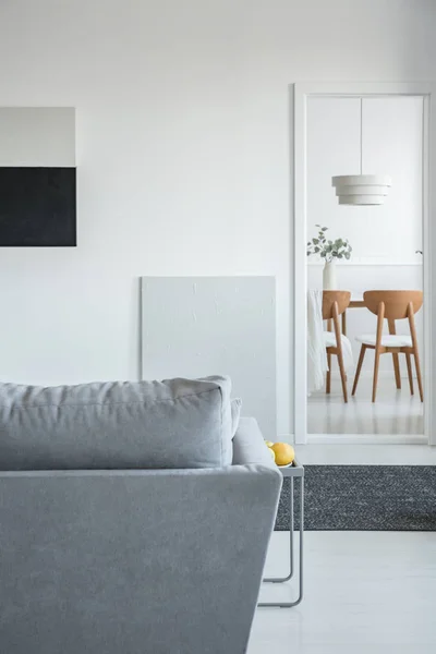 Salon et salle à manger à aire ouverte tendance intérieur avec canapé gris et mobilier en bois — Photo