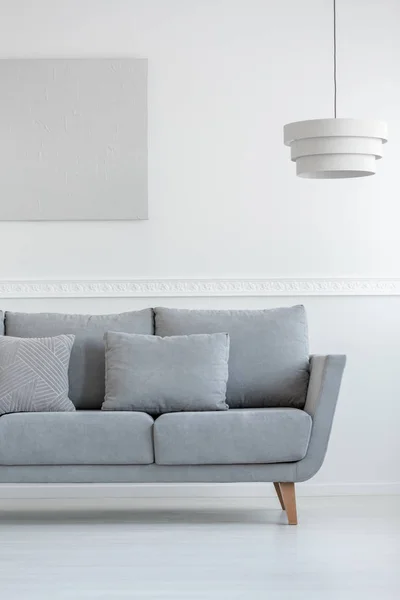 Scandinavische woonkamer sofa in witte dagelijkse kamer interieur met schilderen op de muur en lamp boven — Stockfoto