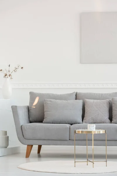 Litet elegant soffbord framför lång skandinavisk soffa i ljust vardagsrum interiör — Stockfoto