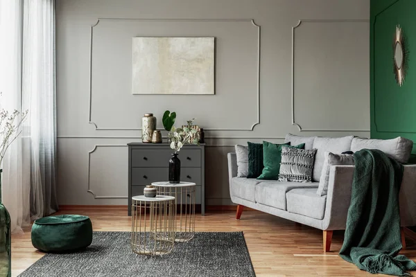 Стильный изумрудно-зеленый и серый дизайн интерьера гостиной с абстрактной росписью на стене — стоковое фото