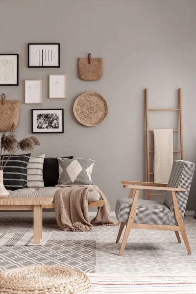 时尚的老式扶手椅，现代客厅内部，带蒲团套装和带毯子的木制斯堪的纳维亚梯子 — 图库照片