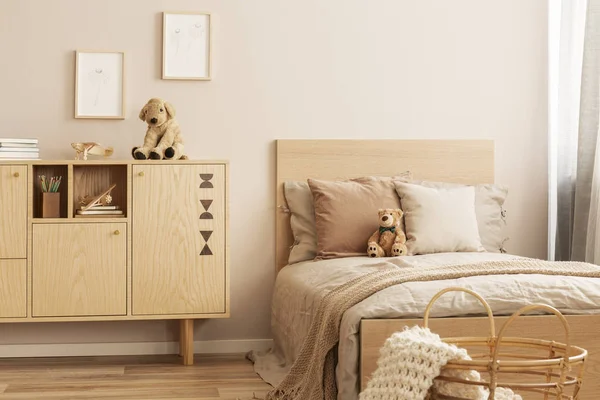 어린이 침실의 싱글 침대 옆에 봉제 인형이있는 세련된 나무 commode — 스톡 사진