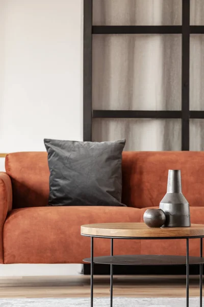 Zwarte vaas op houten salontafel in chique woonkamer interieur met comfortabele sofa — Stockfoto