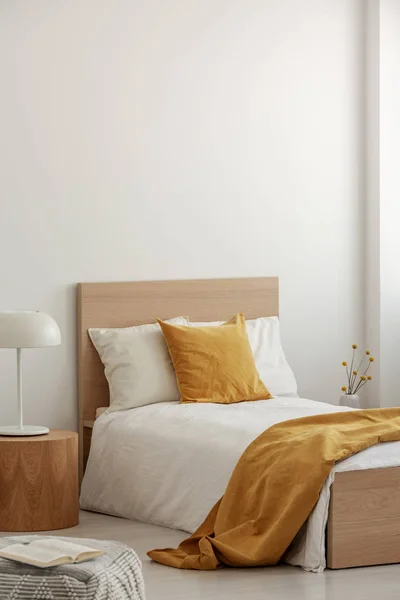 Vita och gula sängkläder på enkel träsäng i modern hotellinteriör — Stockfoto