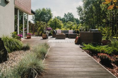 Şık bahçe mobilyaları ile bahçede terasa ahşap yol