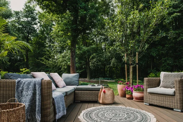 Terrasse de jardin décorée avec canapé en osier scandinave et table basse — Photo