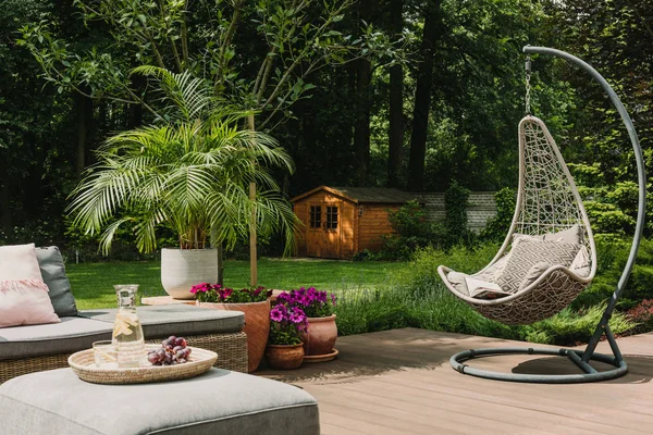 Süslü yumurta koltuğu ve bahçe mobilyalarıyla süslü bahçe dekorasyonu. — Stok fotoğraf