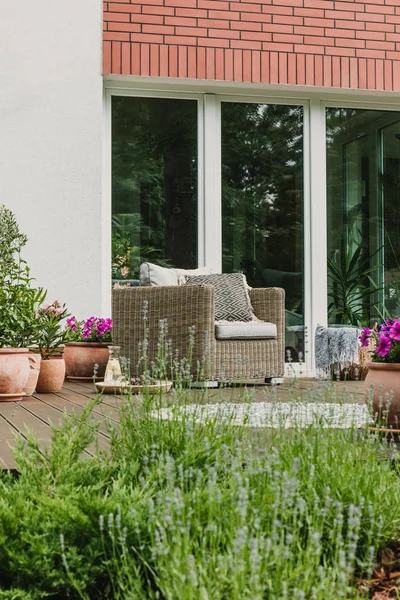 Cómodo sillón de mimbre con almohadas en la terraza de madera de la casa suburbana de moda —  Fotos de Stock