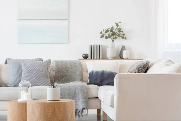 Pastel azul e branco pintura a óleo abstrata na parede branca vazia com mesa de console com flores em vaso e livros — Fotografia de Stock