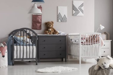 İkizler için sevimli bebek odasıortasında Gri ahşap komodin