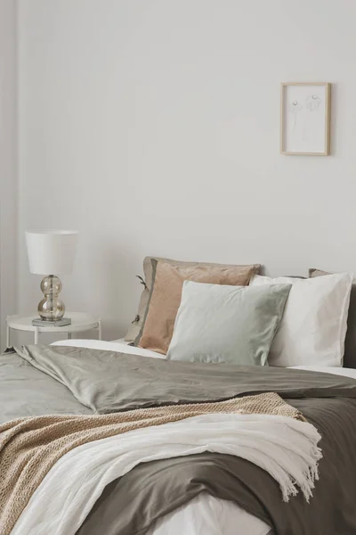 Almohadas coloridas en cama king size con edredón y mantas en el dormitorio inspirado hygge — Foto de Stock