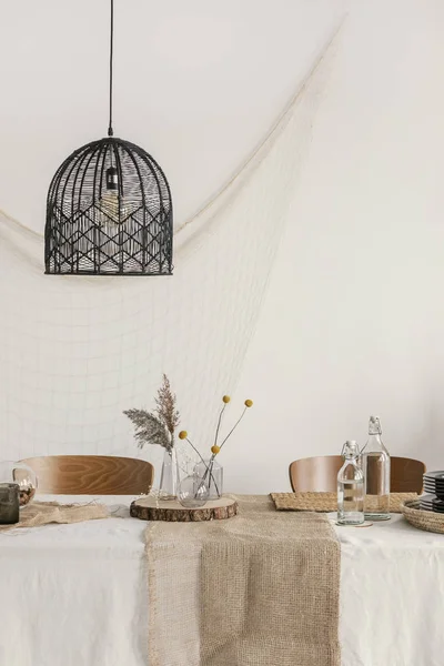 Openwork pendant lamp above the table in dining room