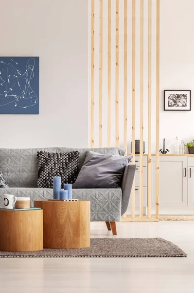 Offene Wohn- und Kücheneinrichtung mit weißen Schränken und grauem Sofa mit Kissen — Stockfoto