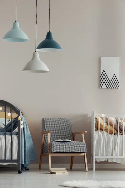 Lampes pastel au-dessus du fauteuil vintage élégant au milieu de la jolie chambre de bébé pour jumeaux — Photo