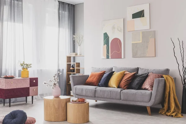 Couchtisch vor grauer Couch im skandinavischen Wohnzimmer — Stockfoto