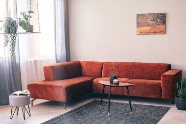 Yastıklı büyük kadife köşe kanepeönünde altlıklar ile zarif küçük ahşap sehpa