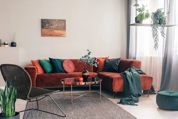 Interiér útulného obývacího pokoje s rohové pohovkou s polštáři a malováním na stěně — Stock fotografie