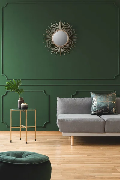 Золота сонячна форма як дзеркало на зеленій стіні інтер'єру вітальні зі скандинавським диваном з подушками — стокове фото