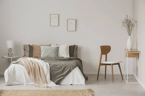 Elegante silla junto a la cálida cama king size en el dormitorio escandinavo —  Fotos de Stock