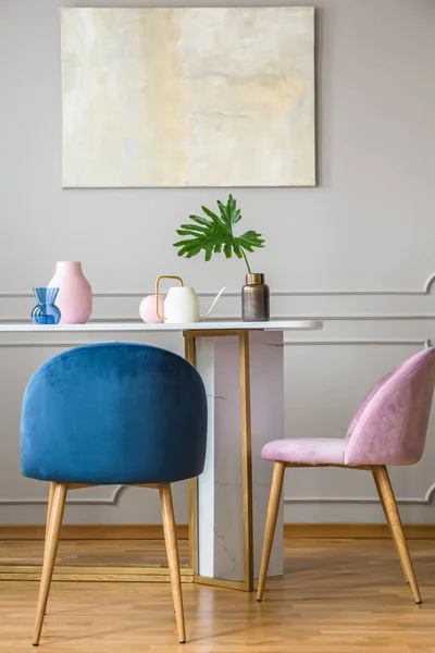 밝은 거실의 작은 식탁에서 벨벳 파스텔 핑크와 가솔린 블루 의자 — 스톡 사진