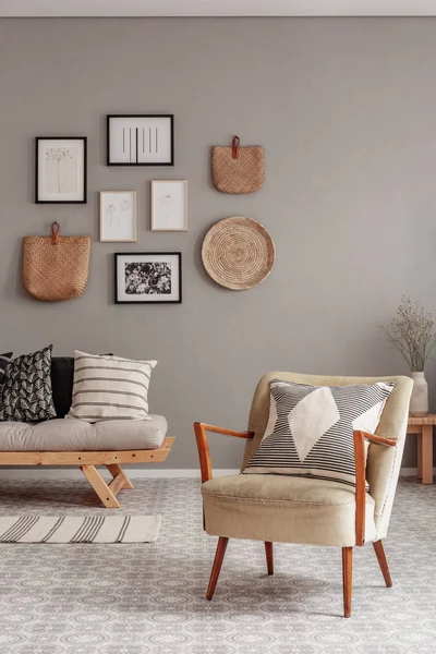 Poltrona de cor creme na moda na sala de estar escandinava interior com galeria de cartazes na parede bege — Fotografia de Stock