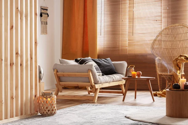 Candela arancione su tavolino in legno in accogliente soggiorno interno — Foto Stock