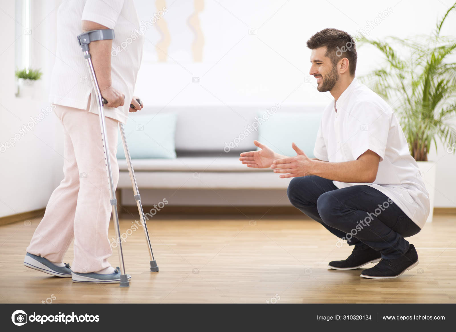 Senior woman at hospital learning how to walk on crunches and supporting male nurse Stock Photo photographee.eu 310320134