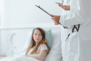 Doktor bir çocuğa tanının ne olduğunu anlatıyor.