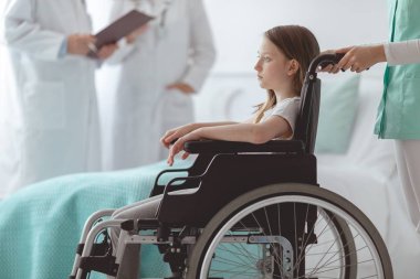 Hastanede tekerlekli sandalyede korkmuş çocuk