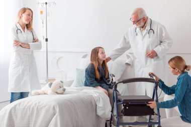 Hastane yatağında nazik yaşlı doktor ve çocuk
