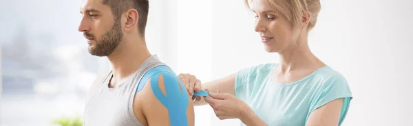 Panoramic view of handsome young man during kinesiotherapy after car accident — Stock Photo, Image