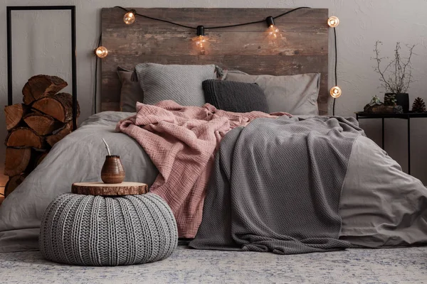 Yerba matte on wooden plate on grey woolen pouf in stylish bedroom interior — Stock Photo, Image