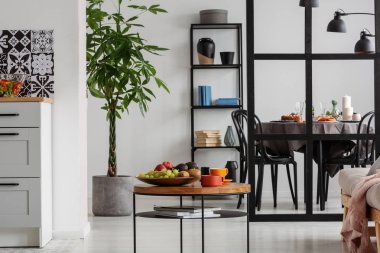 Kahve ve meyveler küçük ahşap sehpanın üzerinde zarif yemek ve oturma odasının iç tarafında.