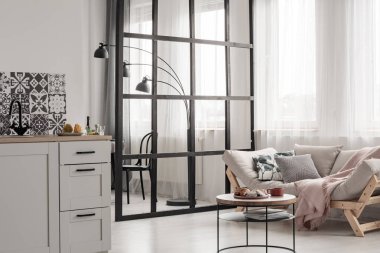 Moda açık uzay mutfağı ve oturma odasının içinde sehpa ve kanepe var.