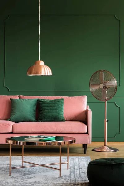 Accents en cuivre dans un élégant intérieur rose pastel et vert émeraude avec canapé et table basse — Photo