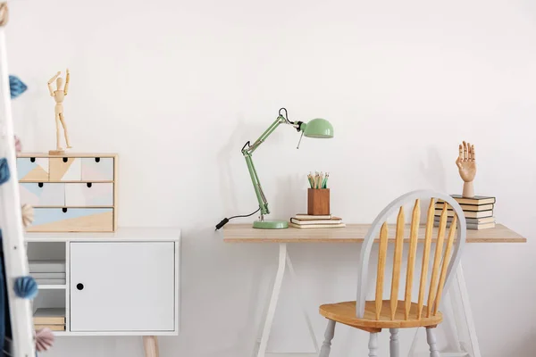 Pilha de livros, mão de madeira e lâmpada de hortelã industrial colorida na mesa de madeira elegante no quarto da criança branca — Fotografia de Stock