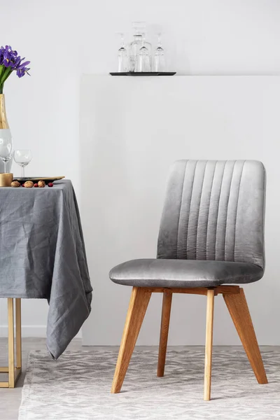 Stijlvolle stoel naast eettafel met grijs tafelkleed in trendy eetkamerinterieur — Stockfoto