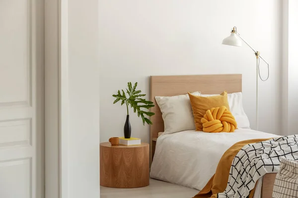 Yellow pillows and blanket on white single wooden bed — Stock Photo, Image