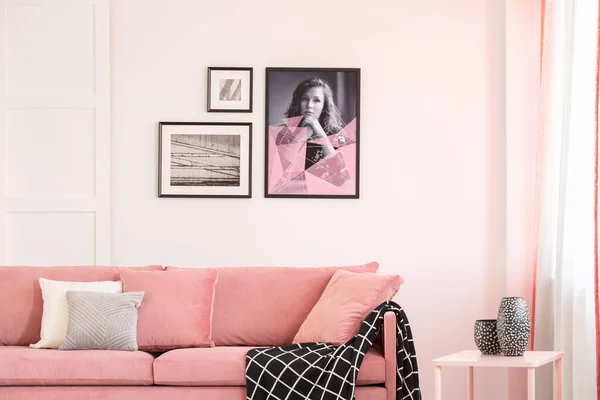 파스텔 핑크 의자가 있는 밝은 거실 내부의 텅 빈 흰 벽에 걸려 있는 포스터들 — 스톡 사진