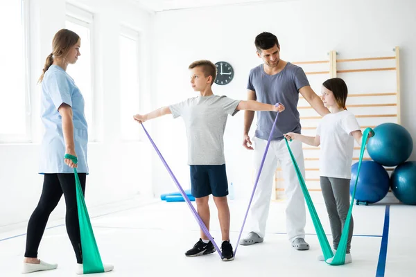 Twee Kinderen Trainen Met Tandvlees Tijdens Revalidatie Met Fysiotherapeuten — Stockfoto