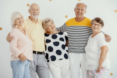 Mutlu kıdemli arkadaşlar bir arada durup gülümsüyor.