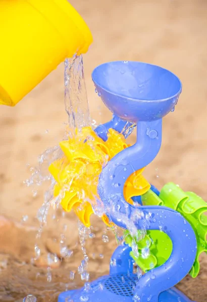 Oyuncak su değirmeni, bir kova su döküldü.