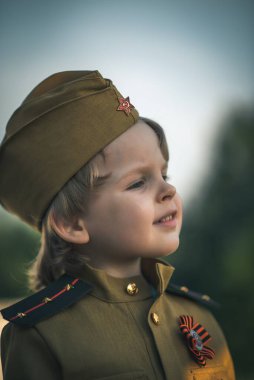 Alay 'ın oğlunun fotoğrafı. 9 Mayıs' taki Rus bayramı onuruna Sovyetler Birliği 'nin askeri üniforması içinde duran çocuk.