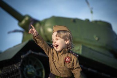 Alay 'ın oğlunun fotoğrafı. 9 Mayıs' taki Rus bayramı onuruna Sovyetler Birliği 'nin askeri üniforması içinde duran çocuk.