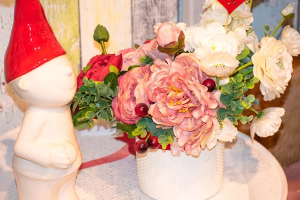 Beyaz porselen bir cüce ve bir vazo çiçekle dekoratif dekorasyon.