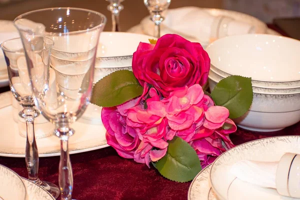 Decorated dining table with champagne glasses and a bouquet of artificial flowers